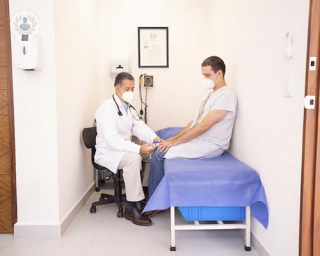 paciente sentado en camilla con doctor