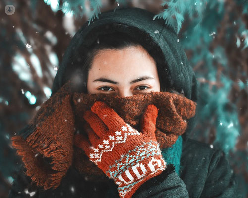 Chica cubriéndose la cara por el frío - alergia al frío - by Top Doctors