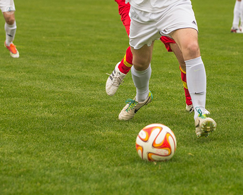 Jugadores de futbol chutando un balón - ozonoterapia para lesiones deportivas - by Top Doctors