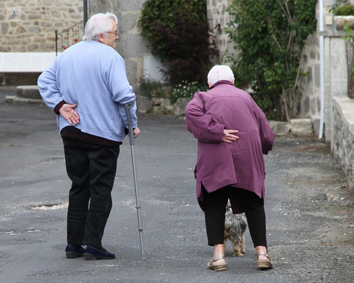 Pareja de ancianos camninando con bastón por la calle - fractura de fémur - Top Doctors