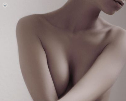 Mujer escondiendo el pecho - aumento de mamas by Top Doctors