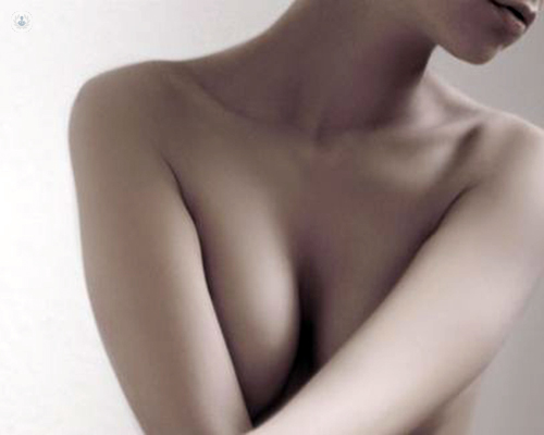Chica tapándose el pecho a medias - cáncer de mama - reconstrucción mamaria by Top Doctors