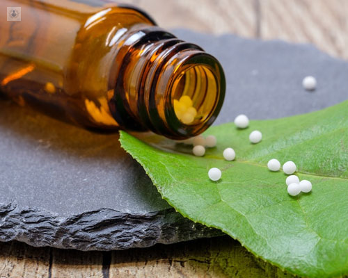 Primer plano de un frasco con pastillas homeopáticas - controversia Homeopatía - by Top Doctors