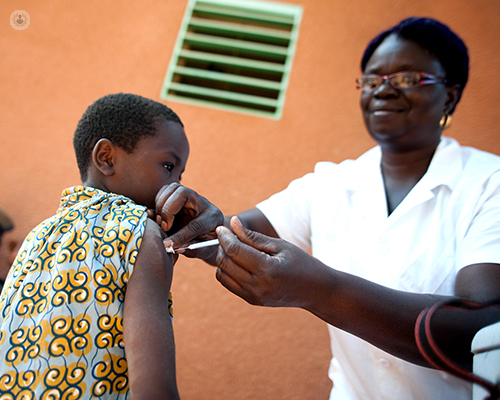 Doctora pinchando una vacuna a un niño - vacuna de la gripe by Top Doctors