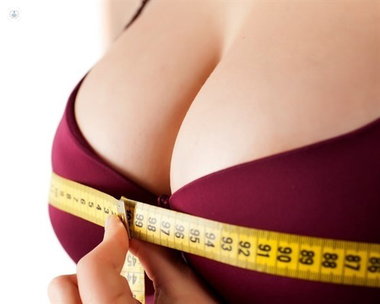 Torso de una chica que está midiéndose el pecho - aumento de mamas - by Top Doctors