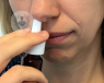 mujer usando un spray nasal 