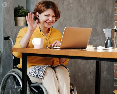Mujer en silla de ruedas haciendo terapia online - daño cerebral adquirido - by Top Doctors