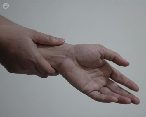 Primer plano de las manos de un paciente, tocándose la parte del interior de la muñeca | by Top Doctors