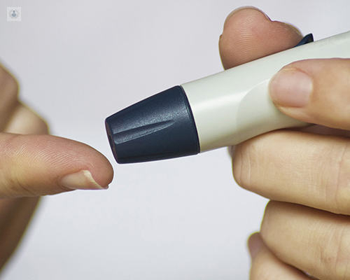 Primer plano de una persona pinchándose para saber el nivel de azúzar en sangre - novedades tratamiento Diabetes by Top Doctors