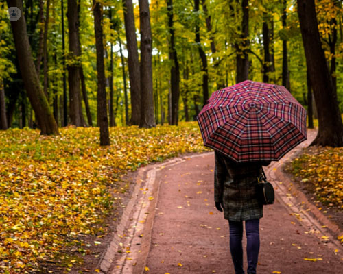 Mujer caminando por el bosque triste - astenia otoñal by Top Doctors