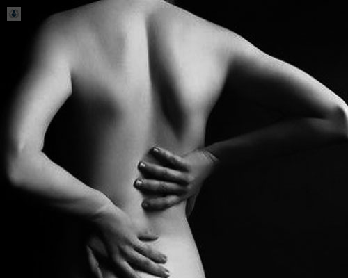 Imagen de una espalda de mujer, agarrándose con dolor - artrosis lumbar - by Top Doctors