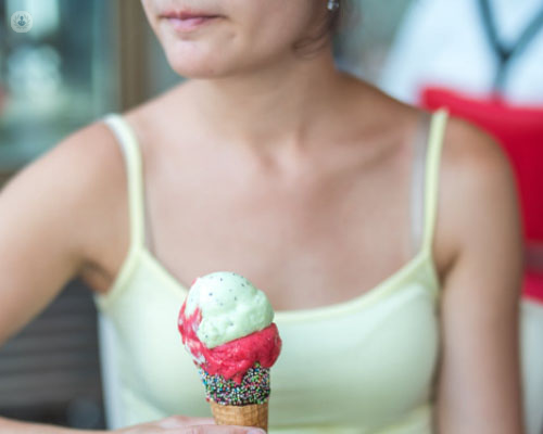Chica comiendo un helado como ejemplo de azúcar en los alimentos by Top Doctors