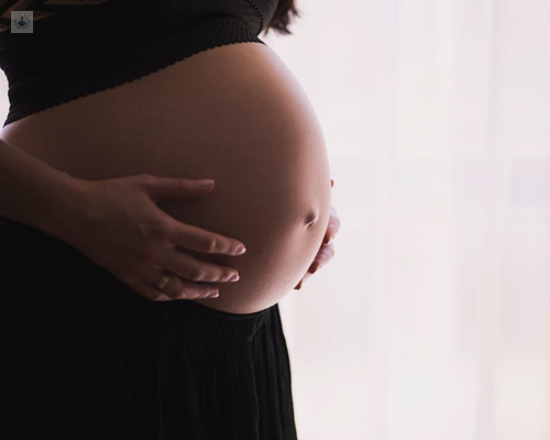 Mujer embarazada tocándose la tripa - estimulación ovárica - by Top Doctors